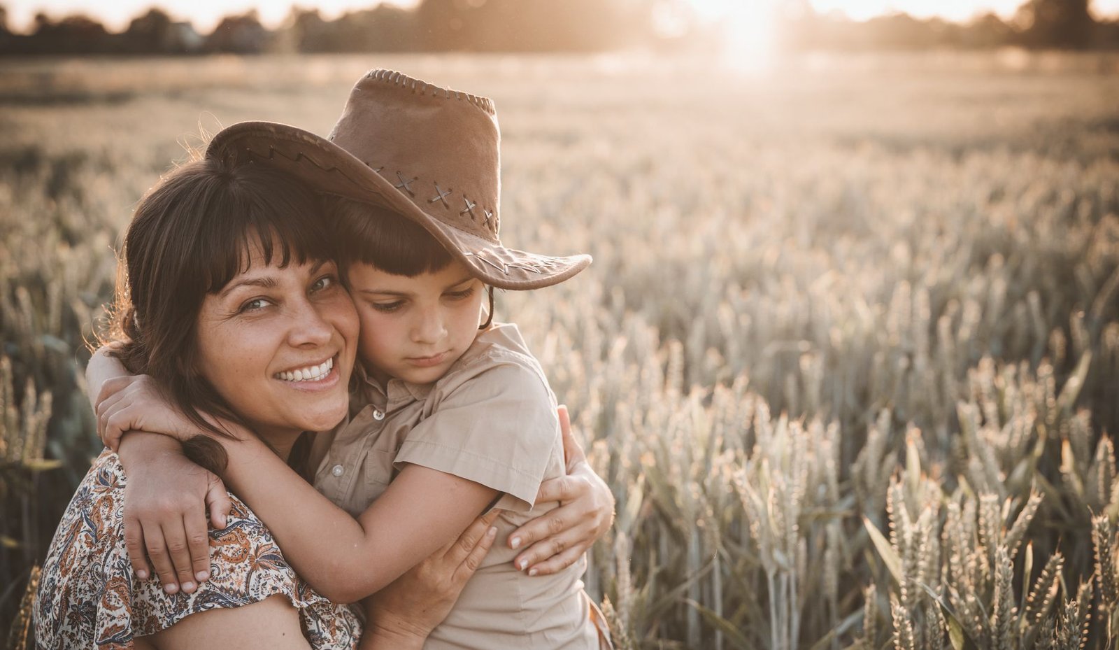 Son hugging mother with bouquet of flowers