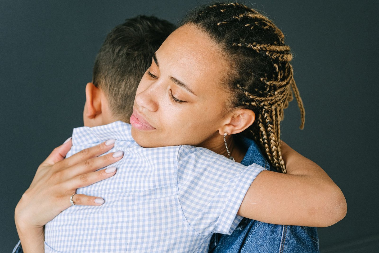 Son hugging mother with bouquet of flowers